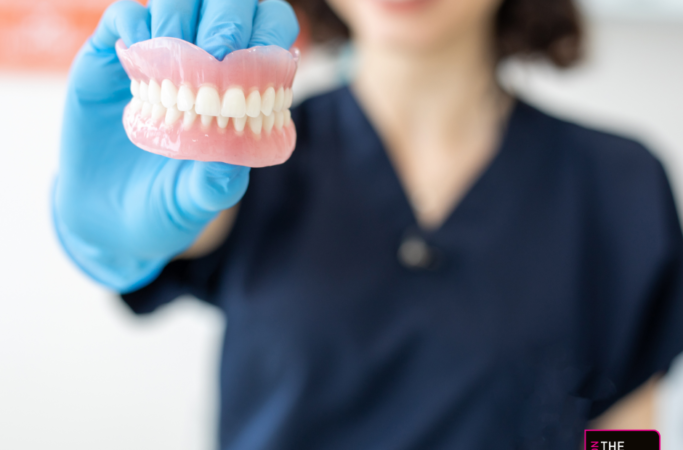 Close up of dentures handheld by a dentist